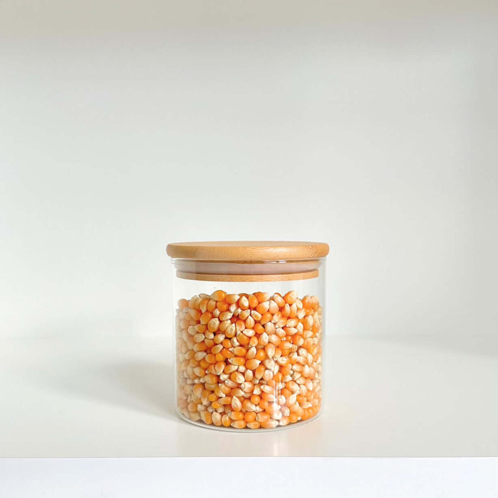 Bamboo glass jar filled with corn, ideal for pantry storage and kitchen organization.