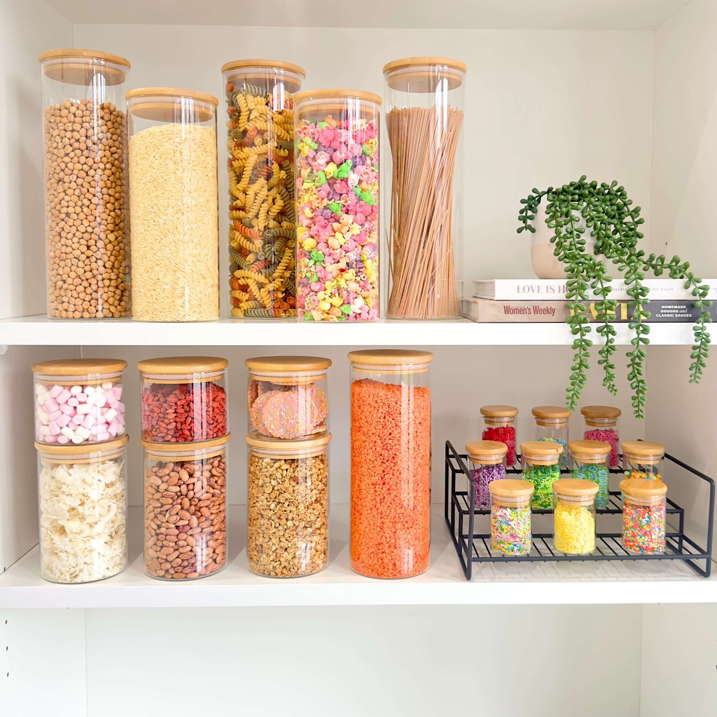 Round glass storage jars with bamboo lids, perfect pantry organisers for pasta and snacks.