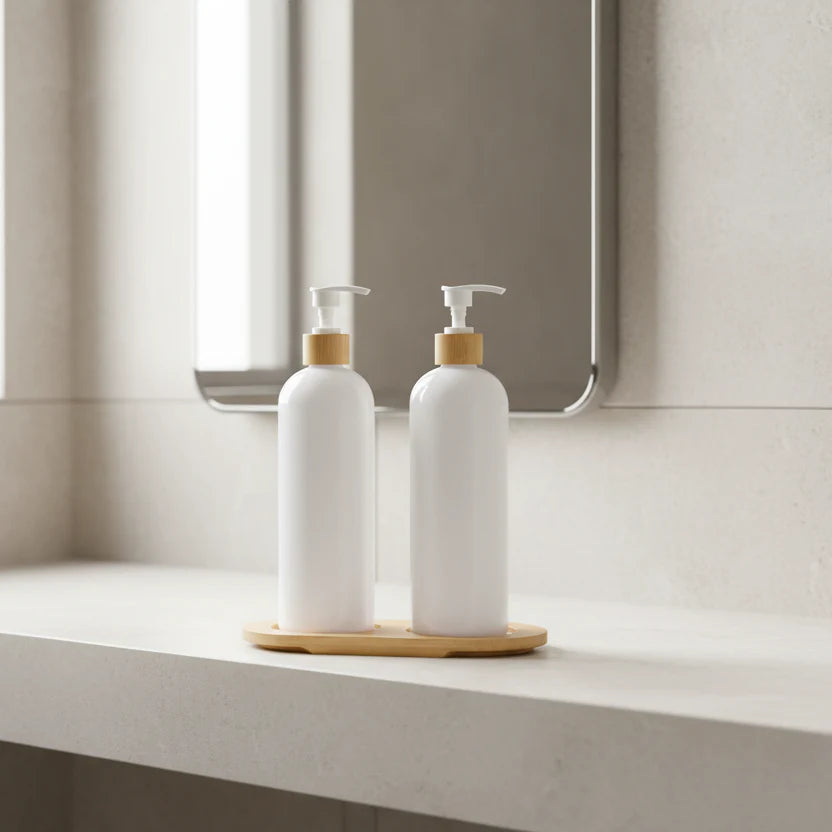 Two white bottles with bamboo caps on a wooden stand against a white background