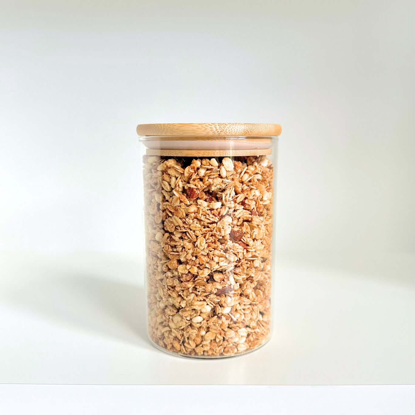 Bamboo lid glass jar with granola for kitchen pantry storage.