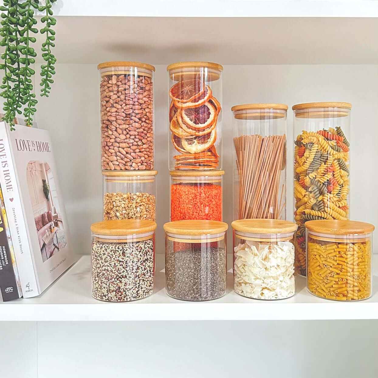 Glass storage jars with bamboo lids used for pantry organization and kitchen storage.